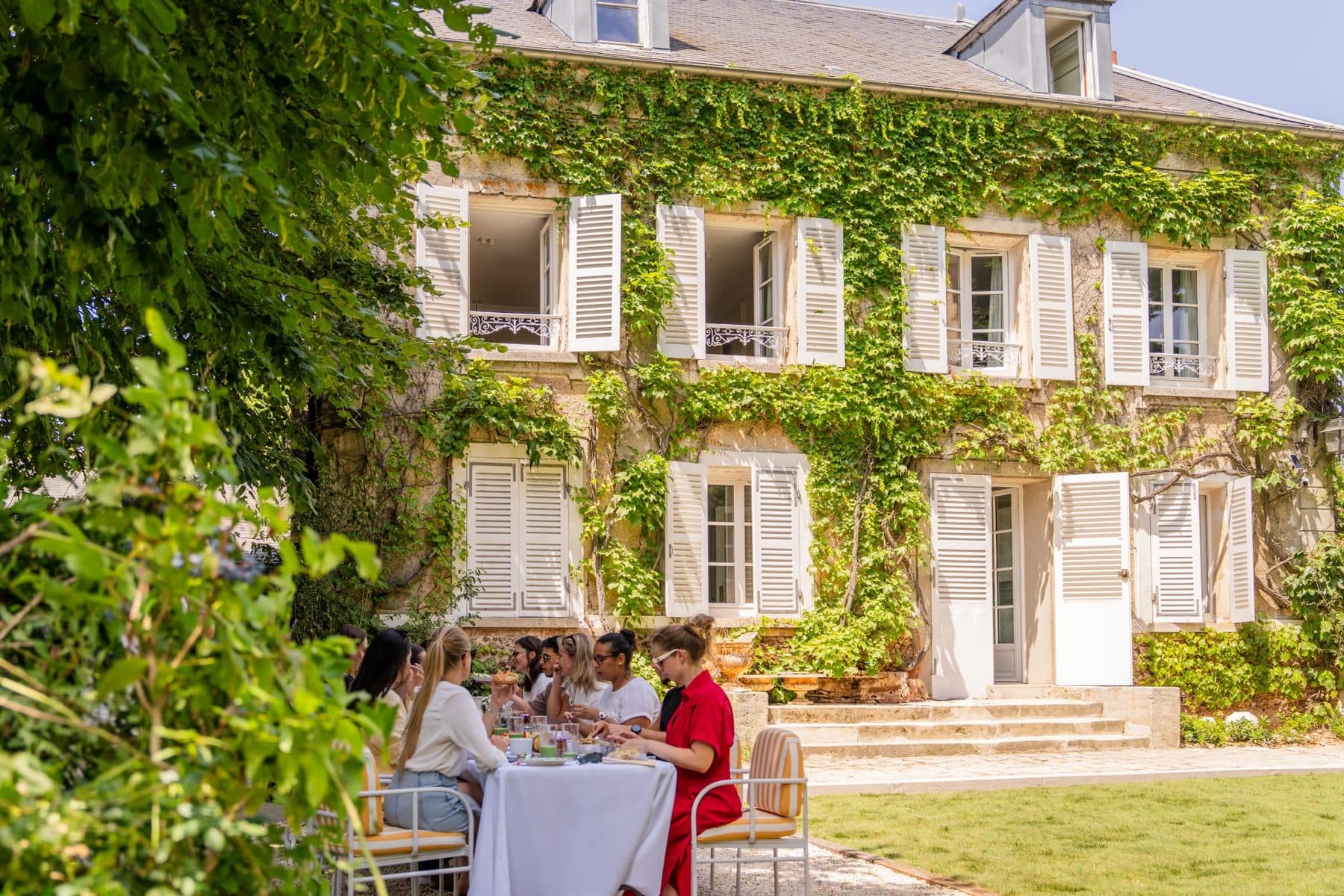 Lunch with friends in the garden, in front of the manor house façade