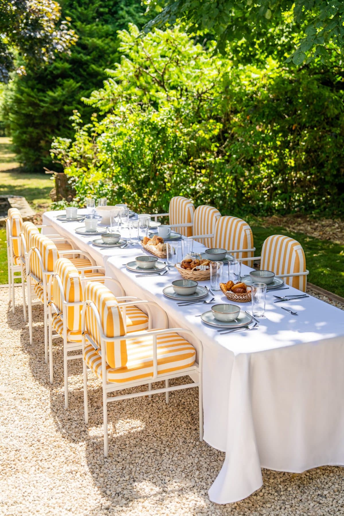 Longue table de banquet dressée dans le parc du domaine pour un séminaire